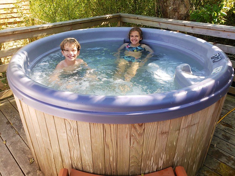 Kids in the deep hot tub in a backyard